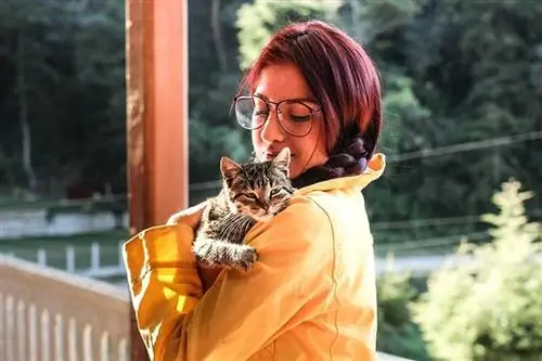 verandada bir kedi tutan kadın