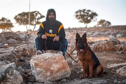 man utomhus med sin schäferhund