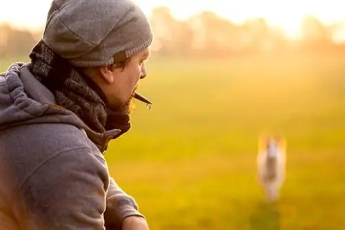 hombre usando un silbato para entrenar a su perro