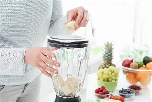 Wanita memasukkan pisang ke dalam blender