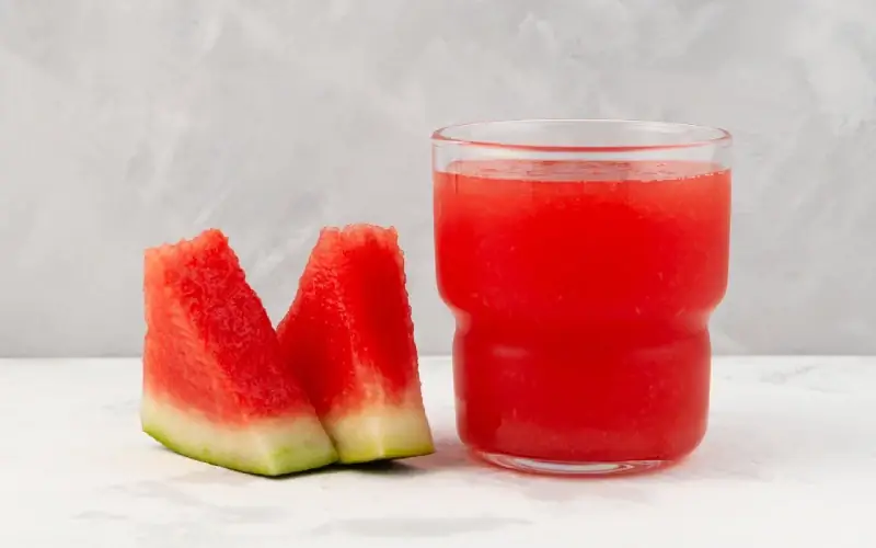 những lát dưa hấu bên cạnh một ly slushie dưa hấu