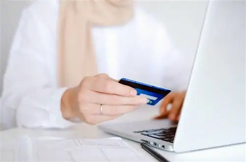 Persona anziana in possesso di una carta di credito per lo shopping online