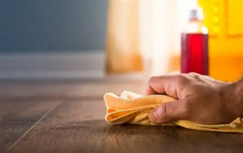 main masculine essuyant le plancher de bois franc